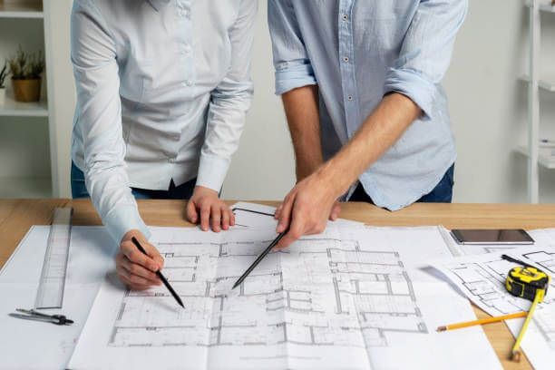 تصميم مخططات معمارية بالرياض على مكتب عمل حديث مع أدوات هندسية وبرامج متطورة مثل أوتوكاد وريفيت